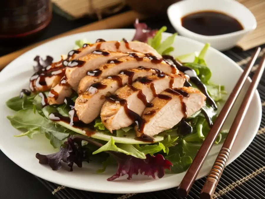 Asian-inspired chicken salad with sesame dressing served on a bed of greens